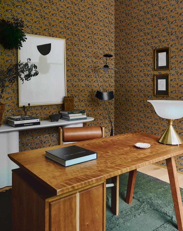Wallpaper-clad walls with artistic accents adding charm to the home office